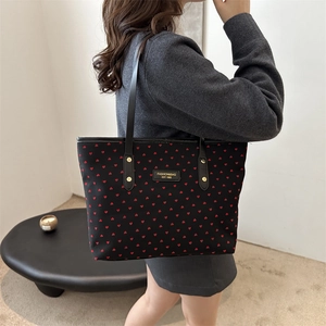 Large black tote bag with red heart print and slim leather handles for fashion commute