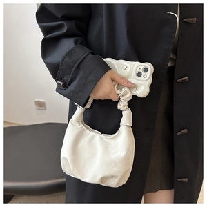 Détail du sac à main crème avec anse froncée et coque de téléphone ondulée à cœur