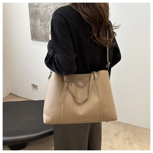 Detail of light brown faux leather tote bag with vertical stitching and adjustable strap