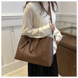 Detailed close-up of brown PU leather tote bag featuring stitching and metal stud accents
