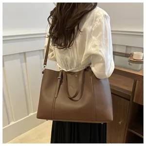 Detail of brown soft PU tote bag with metal rivets and adjustable shoulder strap