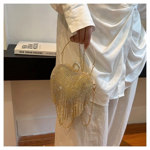 Detail of heart-shaped gold evening bag with rhinestones and tassel fringe charms
