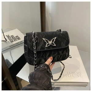 Detail of black pleated crossbody bag with silver butterfly clasp and chain strap