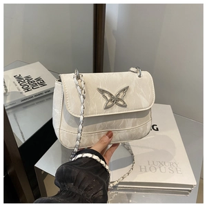 Detailed view of white marble texture leather bag with silver butterfly clasp and chain strap