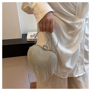 Detail of silver heart-shaped evening bag with shimmering rhinestones and long tassels