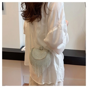 Detailed view of silver heart box bag with sparkling rhinestones and flowing tassels