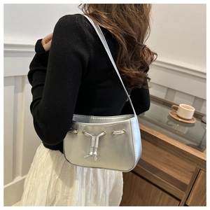 Detail of silver metallic PU shoulder bag with decorative eyelets and drawstring closure