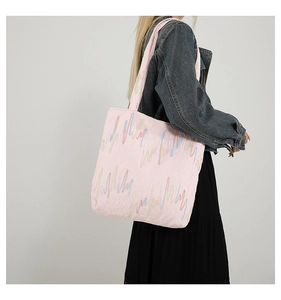Detail of colorful wave embroidery and quilted texture on pink casual tote bag
