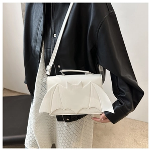 White bat-shaped crossbody bag with wings detail styled on a black leather jacket