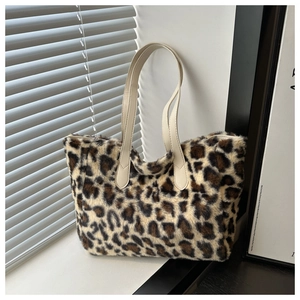 Detail of soft leopard print plush tote bag with light-colored handles in soft daylight