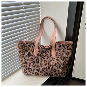 Detail of pink leopard print faux fur tote bag with sturdy leather handles on a windowsill
