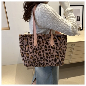 Leopard print plush tote bag shown on shoulder in a cozy interior setting