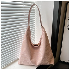 Detail of pink tote bag showing ruched nylon texture and triangle fashion badge