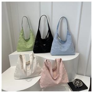 Multi-colored pleated hobo tote bags with triangular logo on minimalist display