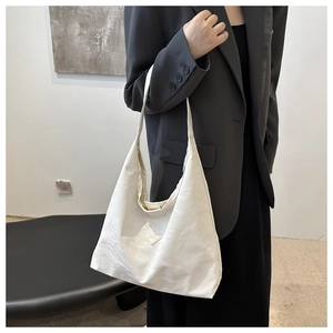 Close-up of cream-white large capacity hobo bag featuring fashion triangle logo detail