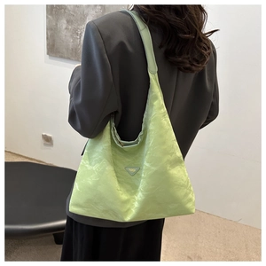 Detailed side view of light green pleated tote bag with fashion triangle logo plaque