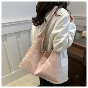 Detailed view of pink nylon tote bag with triangle logo and textured pleated fabric