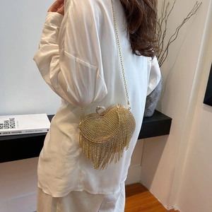 Golden heart-shaped evening clutch bag with sparkling rhinestones and long tassels