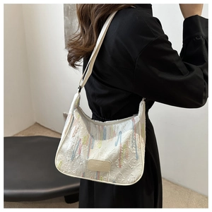 Detailed view of white nylon dumpling bag with colorful tassels and adjustable strap