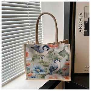 Detail der Jute-Tragetasche mit Vintage-Vogelprint und rustikalen Hanfseil-Griffen