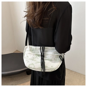 Detailed close-up of water ink tie-dye nylon bag with green pastoral print and pleats