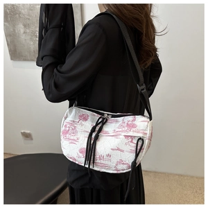 Detail of white tie-dye crossbody bag featuring pink floral patterns and black drawstring