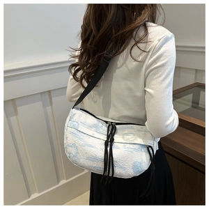 Side view of half-moon ink painting nylon crossbody bag worn by a model