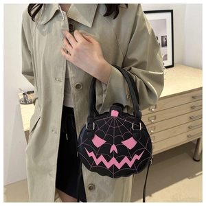 Detail of pumpkin-shaped handbag with pink spider web embroidery and dual handles