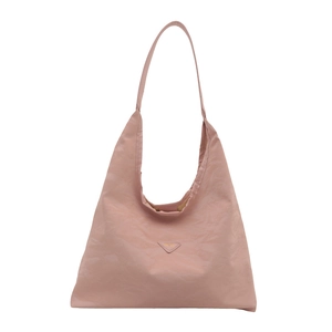 Light pink nylon tote bag with large capacity and iconic triangle patch on white background