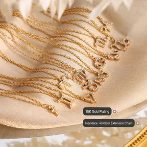 18K gold plated zodiac sign necklace with white rhinestones on champagne silk fabric