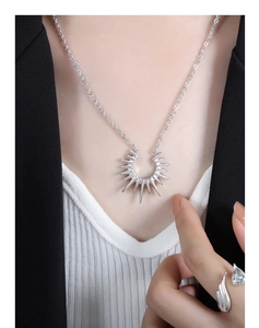 Détail du collier pendentif étoile argenté et de la bague en zircon goutte sur modèle