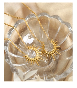 Détail de deux pendentifs étoile dorés sur tissu satiné et décor en verre