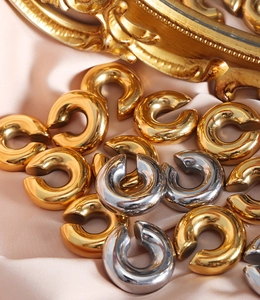 Détail de manchettes d'oreilles en C dorées et argentées sur tissu en satin doux