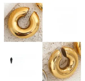Détail des créoles en C en acier titane plaqué or 18 carats sur fond de pierre