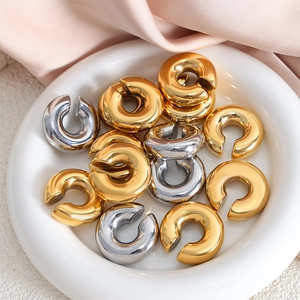 Bagues d'oreilles épaisses style français en or et argent sur plateau blanc