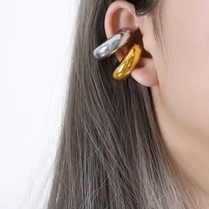 Boucles d'oreilles clips épaisses en titane poli or et argent sur un mannequin