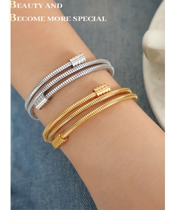 Gros plan de bracelets spirales superposés en or et argent à texture métallique