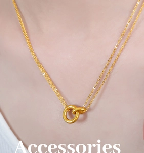 Primer plano del colgante de doble anillo entrelazado en una cadena de acero de titanio oro