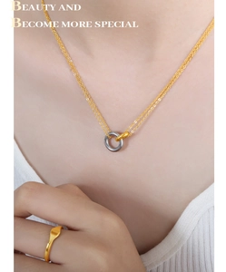 Detalle de collar de doble capa con anillos bicolor y anillo dorado a juego