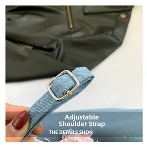 Close-up of adjustable light blue denim shoulder strap with silver metal buckle detail