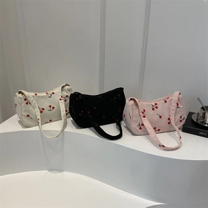 Three corduroy underarm bags in white, black, and pink with embroidered cherry patterns