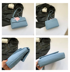 Macro view of blue denim bag showing pink fabric patches and thick blue chain strap