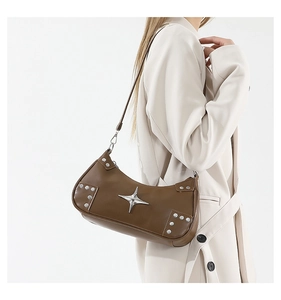 Détail du sac hobo en cuir marron foncé avec boucle étoile argentée et rivets métal