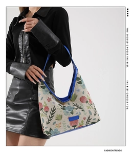 Détail de la texture jacquard florale et de la sangle en cuir bleu du sac rétro