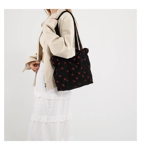 Close-up of black strawberry print tote bag showing fabric texture and vibrant pattern