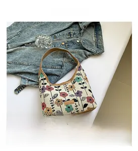 Détail du sac en toile à imprimé floral avec bordure en cuir et écusson mode