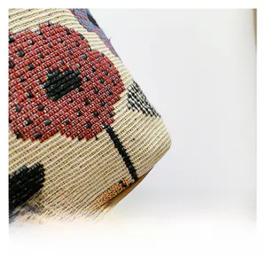 Gros plan sur un tissu jacquard texturé aux motifs floraux colorés sur toile beige