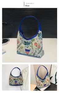 Detail view of floral canvas shoulder bag with blue leather trim and zip closure