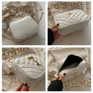 Détails du sac bandoulière blanc matelassé avec large sangle imprimée et bijou cerf