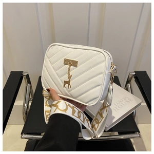 Détail du sac bandoulière matelassé blanc avec breloque cerf dorée et large bandoulière